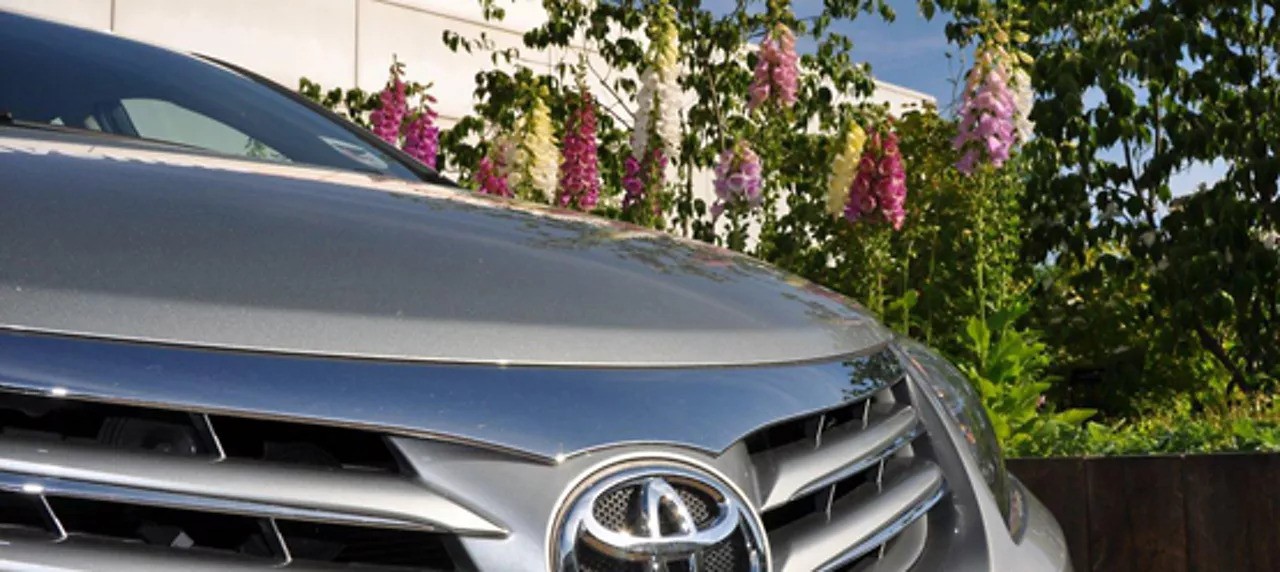 паркирана Toyota пред цветя