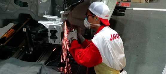 Работник ремонтира каросерията на автомобила
